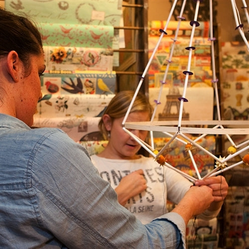 People making a pajak using paper craft straws