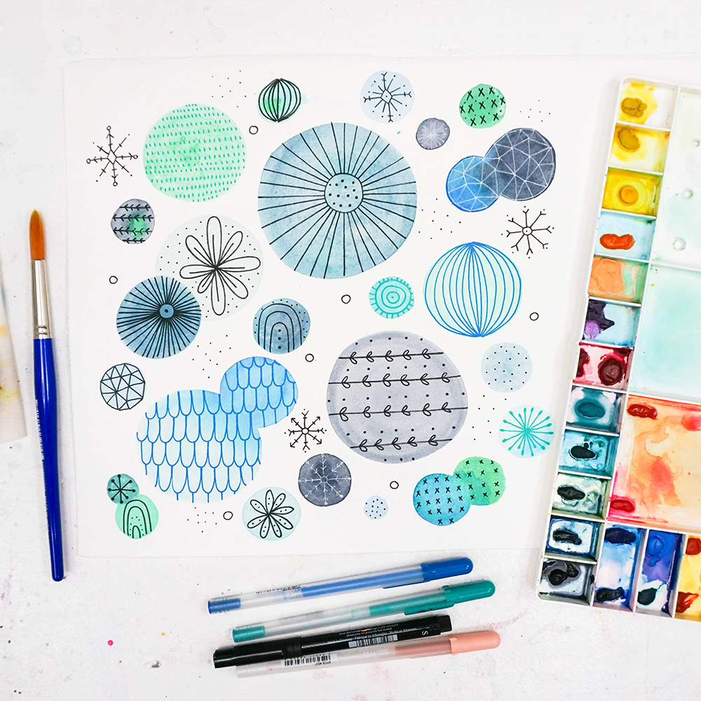 The Joy of Watercolor Doodling Class samples with circle patterns in blue, painting materials, and pens