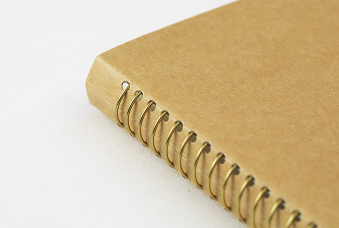 Midori Spiral Ring Paper Pocket Notebook is hand bound with gold rings and features a cover made of hearty kraft stock, ready for your personal touch. 