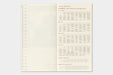 A printed metric measure and equivalence reference card with a left-hand conversion scale and a right-hand table section titled 'Traveler's Information' in English and Chinese, shown on a light gray background.