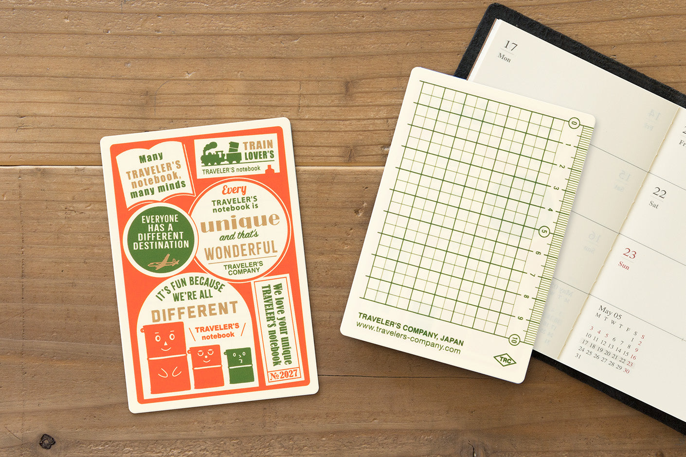 TRAVELER'S notebook 2027 Passport Plastic Sheet showing front of sheet and back of sheet sitting on an open TRAVELER'S notebook (not included)