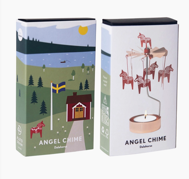 Two product boxes for Angel Chime Dala horse candles shown on a light gray background. One box features a colorful illustration of a Swedish landscape with a red house, trees, lake, and flag, while the other shows the white candle holder design with a red dala horse on a metal stand.