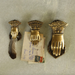 Brass Hand Clips shown in all 3 sizes with small holding a featherm medium, holding postcards, large holding nothing