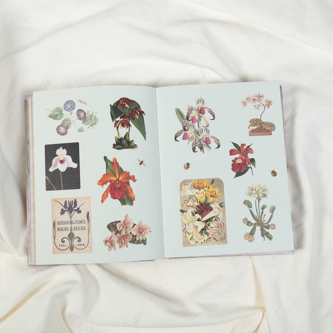 Open book with floral illustrations on a white fabric background