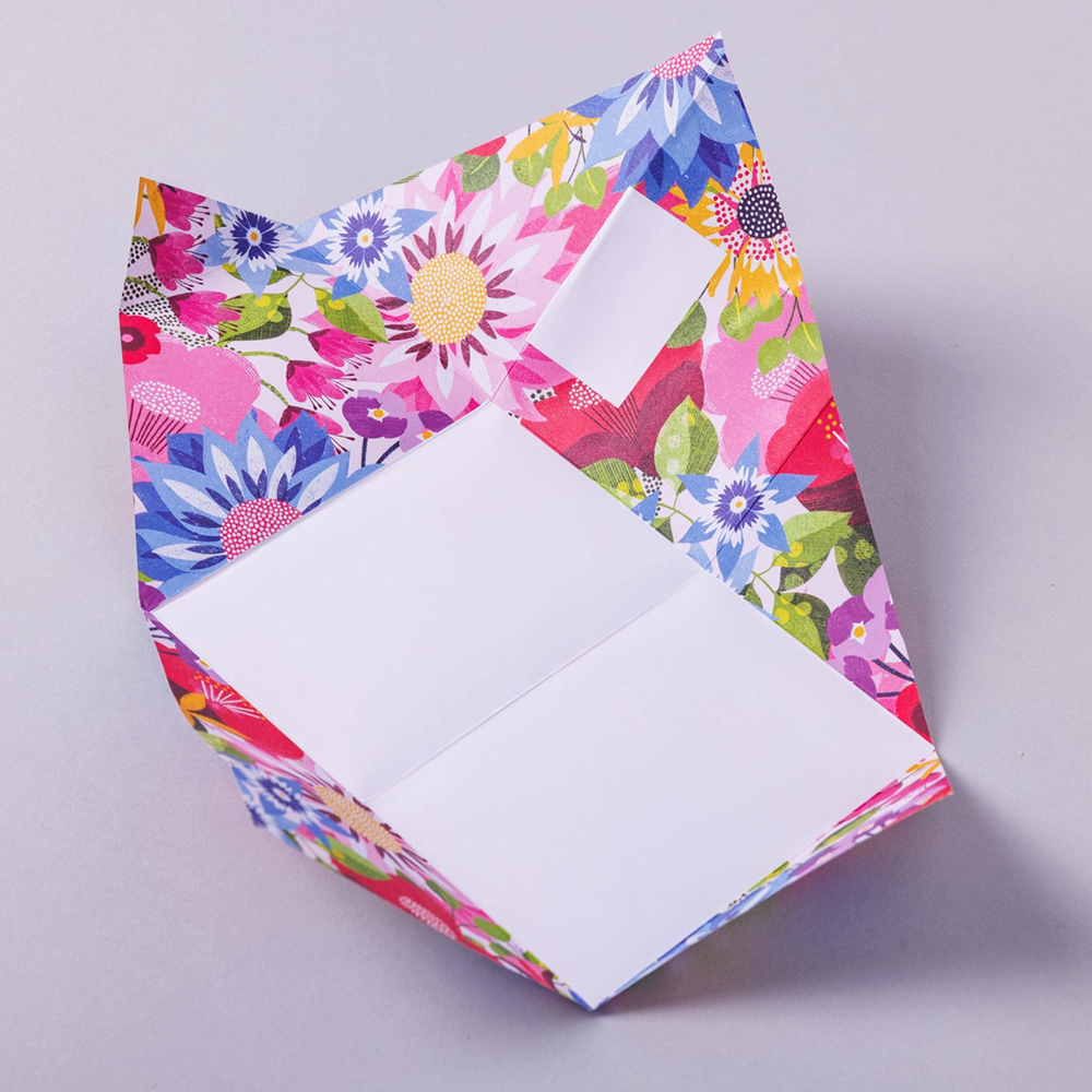 Colorful floral-patterned writing paper with a white square inside for writing on a light gray background