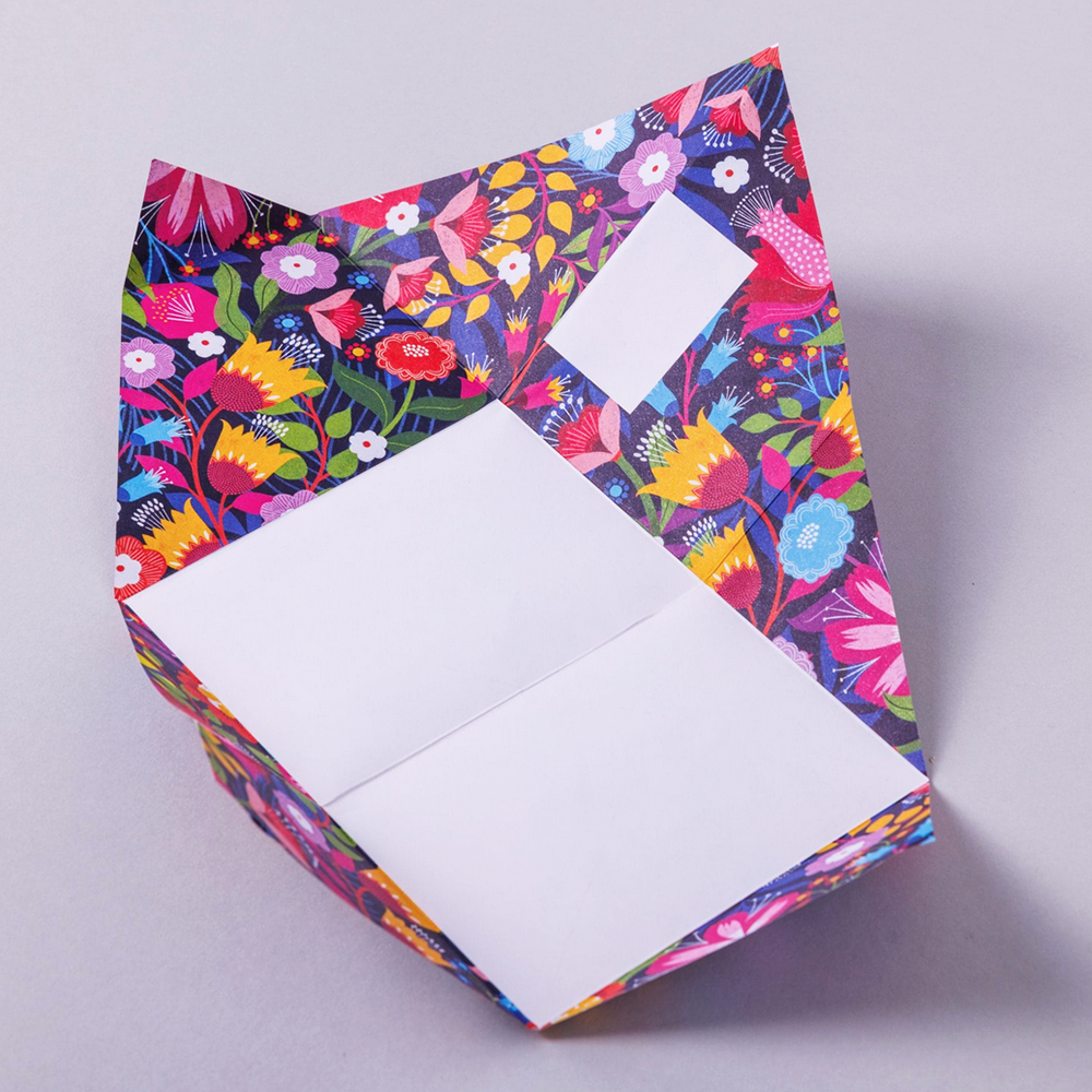 Colorful floral-patterned writing paper with a white square inside for writing on a light gray background