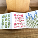 Accordion fold book with alphabet and flower illustrations on a wooden surface