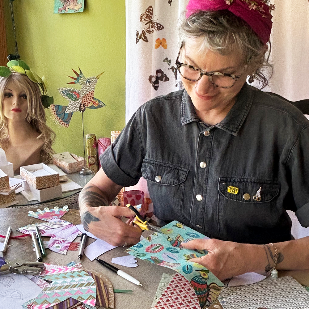 Nanci cutting decorative paper  with colorful materials in a home setting