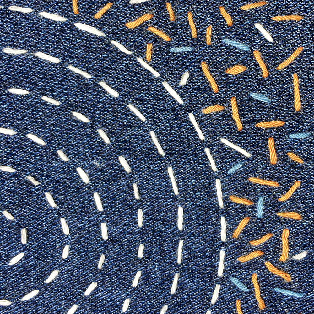Sashiko Patch Class with white thread circular pattern and random stitches in 3 colors stitched onto blue fabric- detail