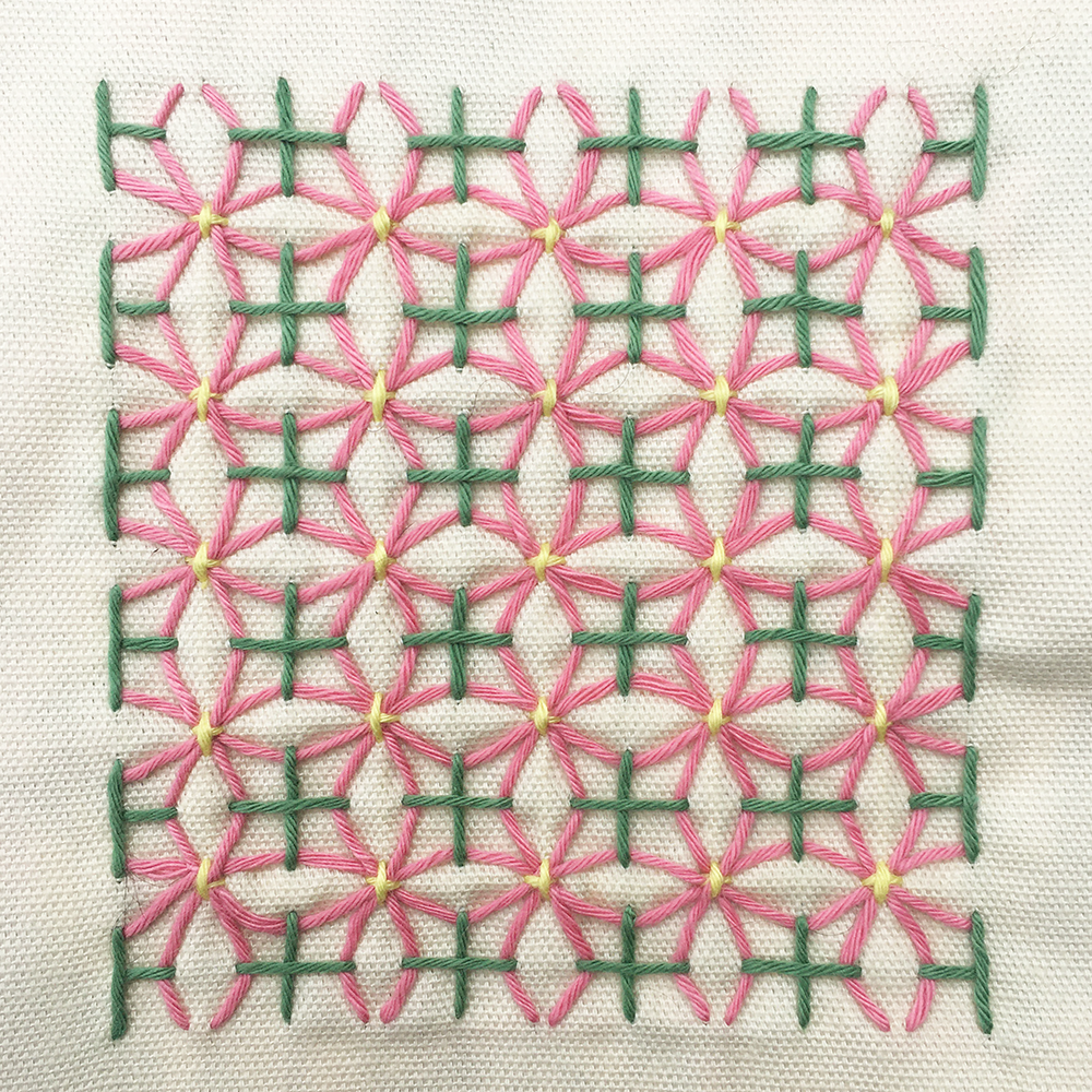 Sashiko Patch Class stitch pattern on white fabric with pink and green thread