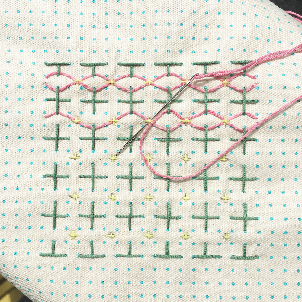 Sashiko Patch Class stitch pattern on white fabric with pink and green thread- in progress with needle