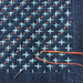 Sashiko Patch Class stitch pattern on blue fabric with light blue and orange thread- in progress with needle