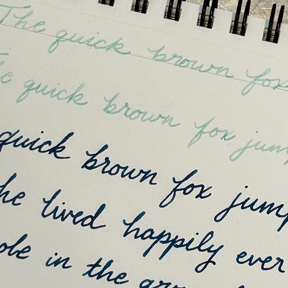 Handwritten text on a notepad with blue and black ink.