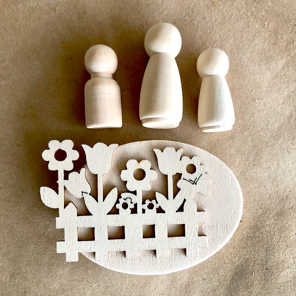 Three wooden peg dolls and a decorative wooden panel with floral design on a beige background.