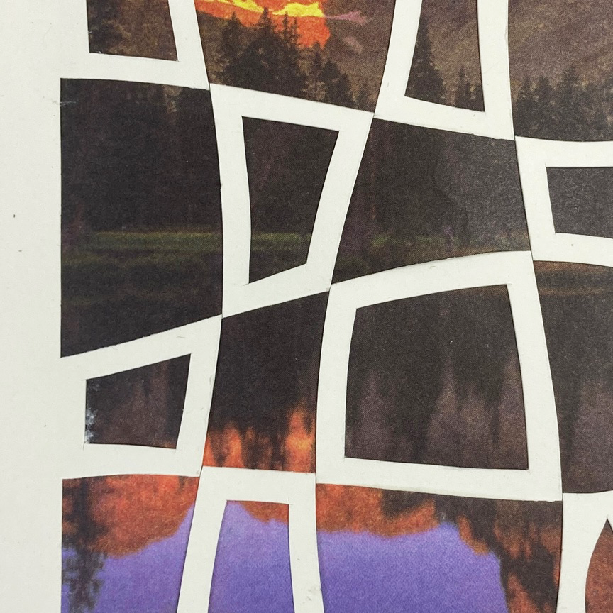 Up close detail of greeting card with mountain and lake design with white cut paper geometric pattern laid on top.