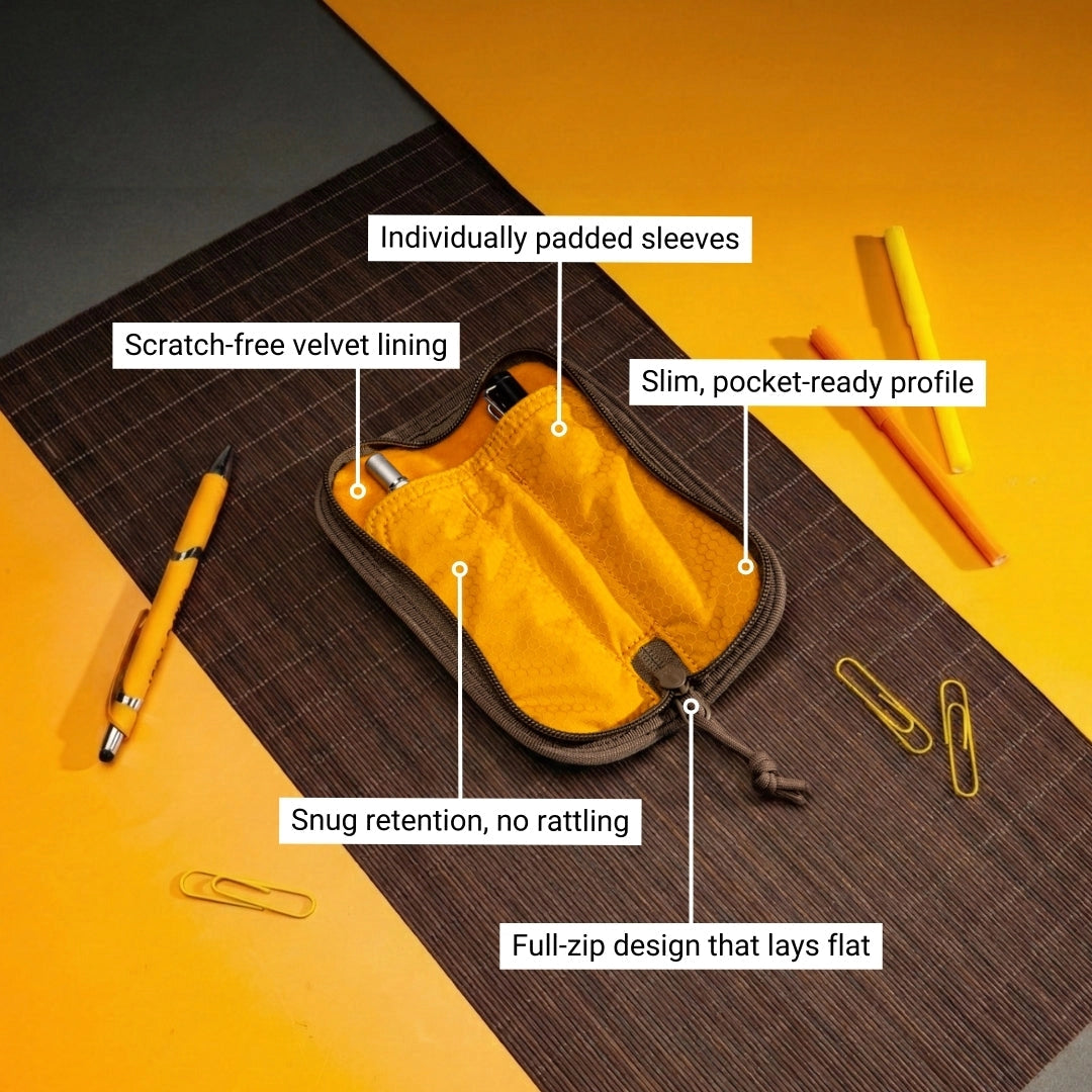 Lochby Duo Pen Pouch shown lying open with yellow interior, with two sample pens (not included) show in pouch alongside other items (not included)