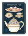 Notebook cover with afternoon tea design featuring teacups, cakes, and a teapot on a dark blue background.