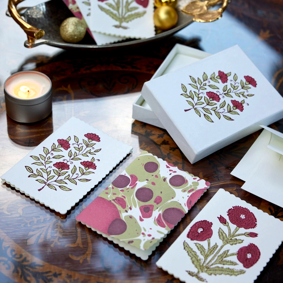 Card box with three card styles displayed on a table with a candle