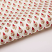 Paper with red and green floral and leaf repeat pattern on a white background