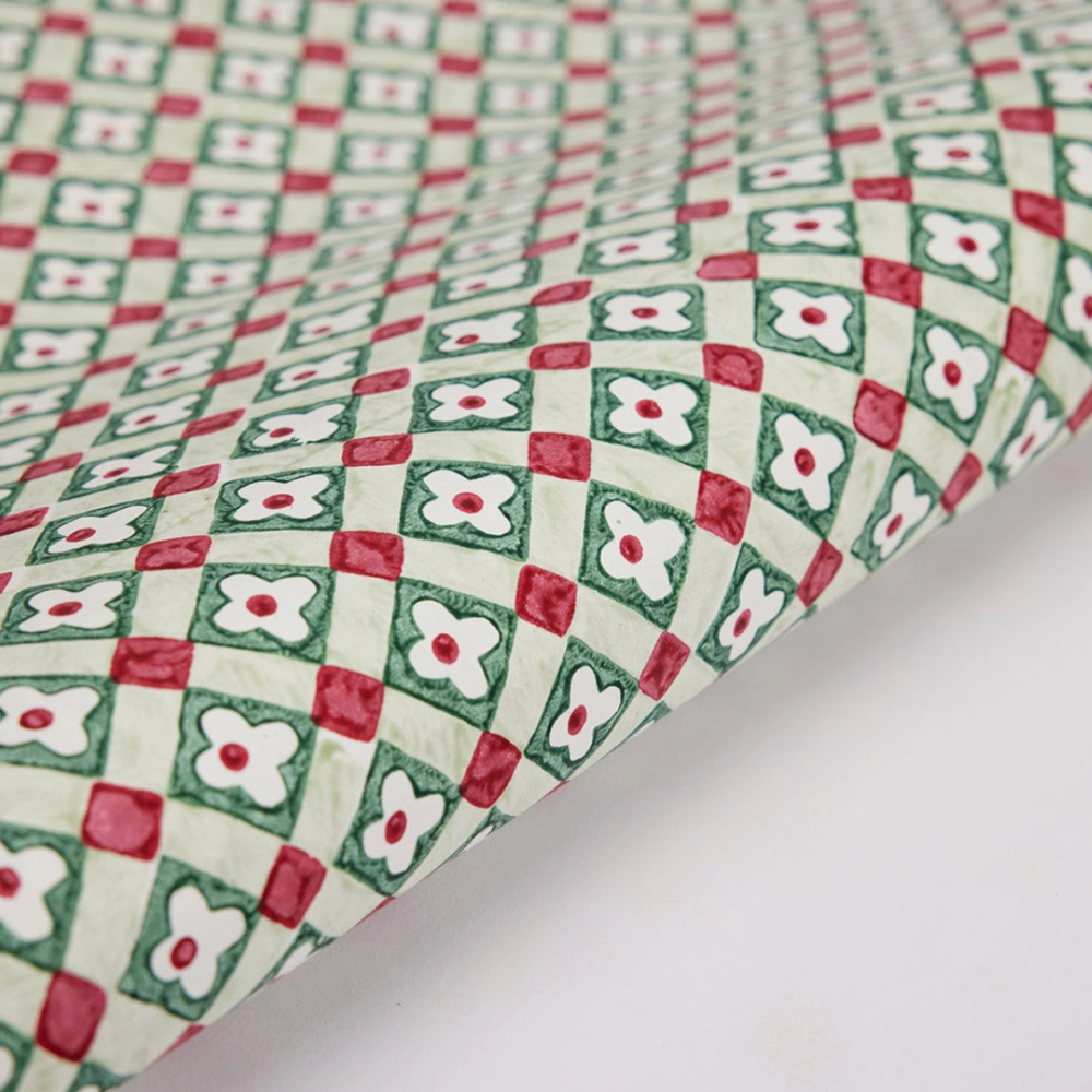 Patterned paper with red, green, and white design on a white background
