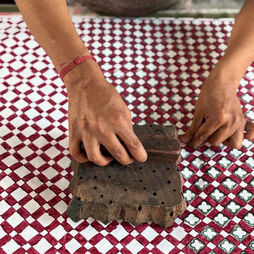 Person with wooden stamp demonstrating the block printing process