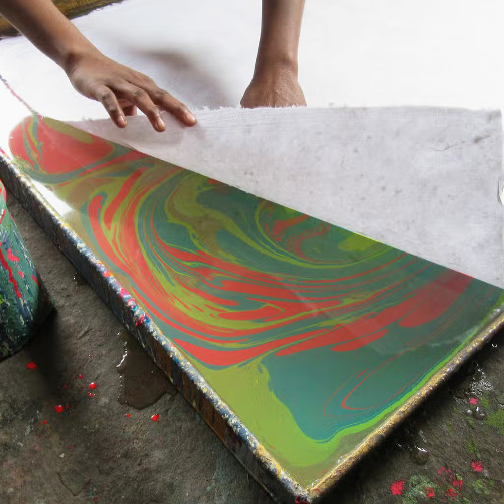 Paper marbling process- White sheet being laid on color
