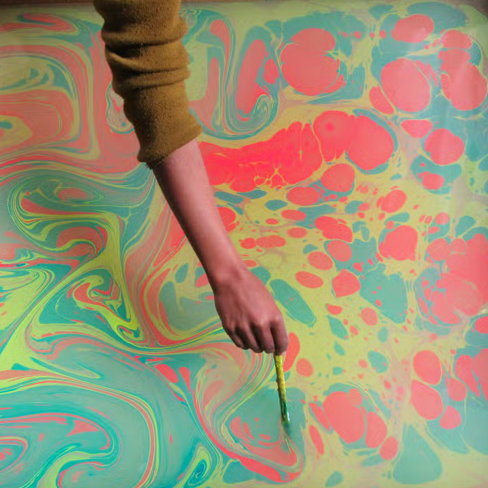paper marbling process- Person creating marbled pattern on water