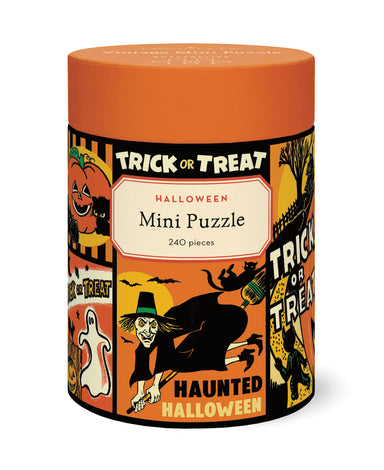 A cylindrical puzzle box for a Halloween mini puzzle, featuring an orange lid and a colorful Halloween-themed label with illustrations of a witch, pumpkin, ghost, and bats. The label reads 'TRICK OR TREAT HALLOWEEN Mini Puzzle 240 pieces' and 'HAUNTED HALLOWEEN'.
