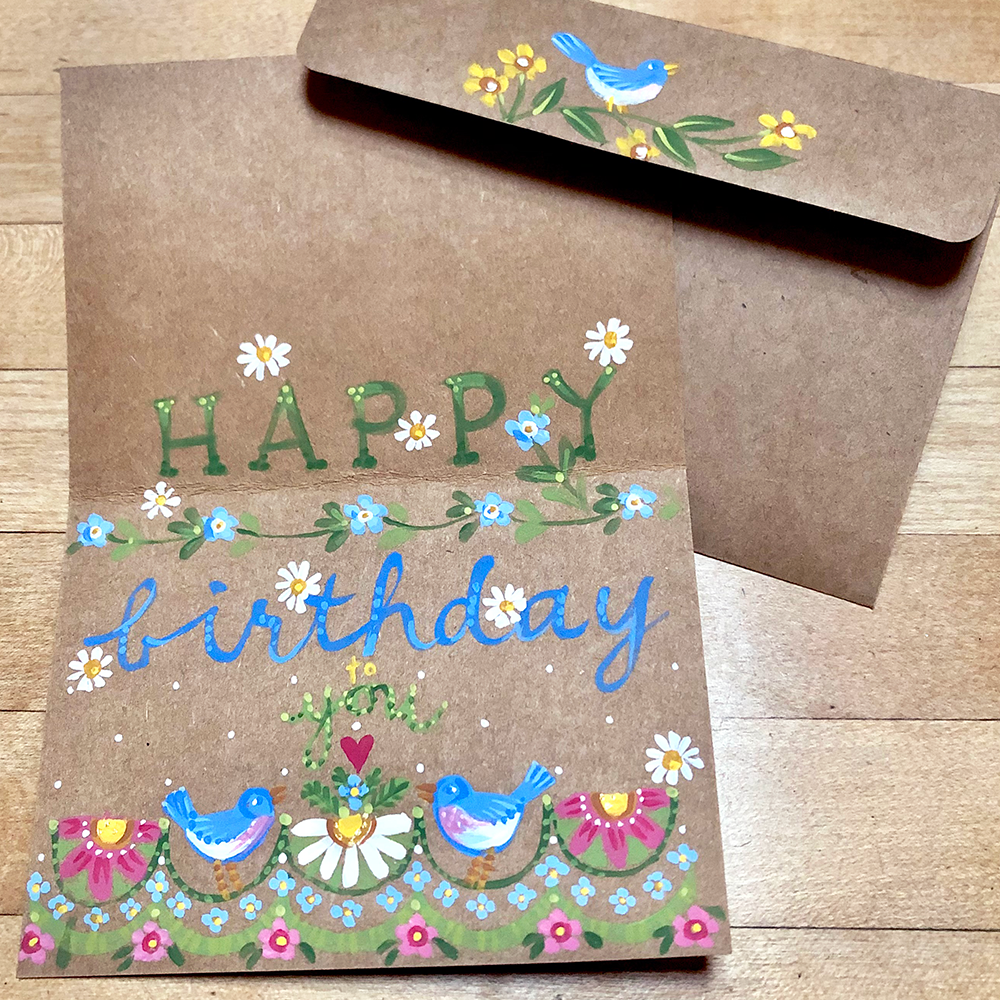 Birthday card with birds and flowers on a brown background