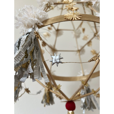 Handmade palm leaf star garland add as an embellishment to a pajak paper and straw chandelier
