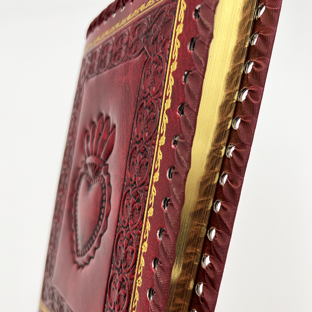 Red Sacred Heart Refillable Leather Journal showing whip stitch along edge and gold edging on refill