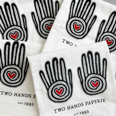 Two Hands Paperie Cotton Tea Towel- 4 shown with black ink and red hearts in hands