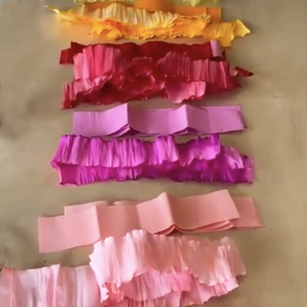 Stack of colorful ruffled crepe paper layers on a beige background