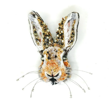 Decorative rabbit head beaded brooch on a white background