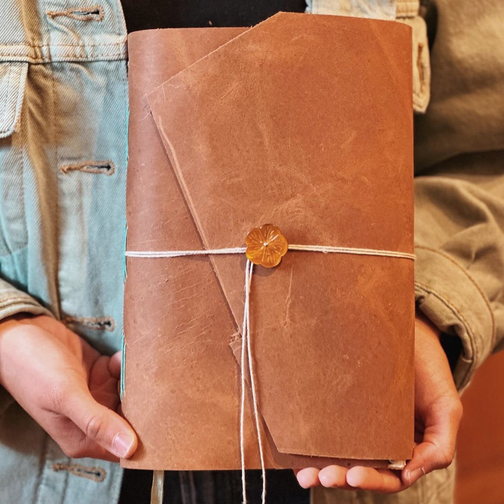 Medieval Leather Journal Class sample with student holding finished book