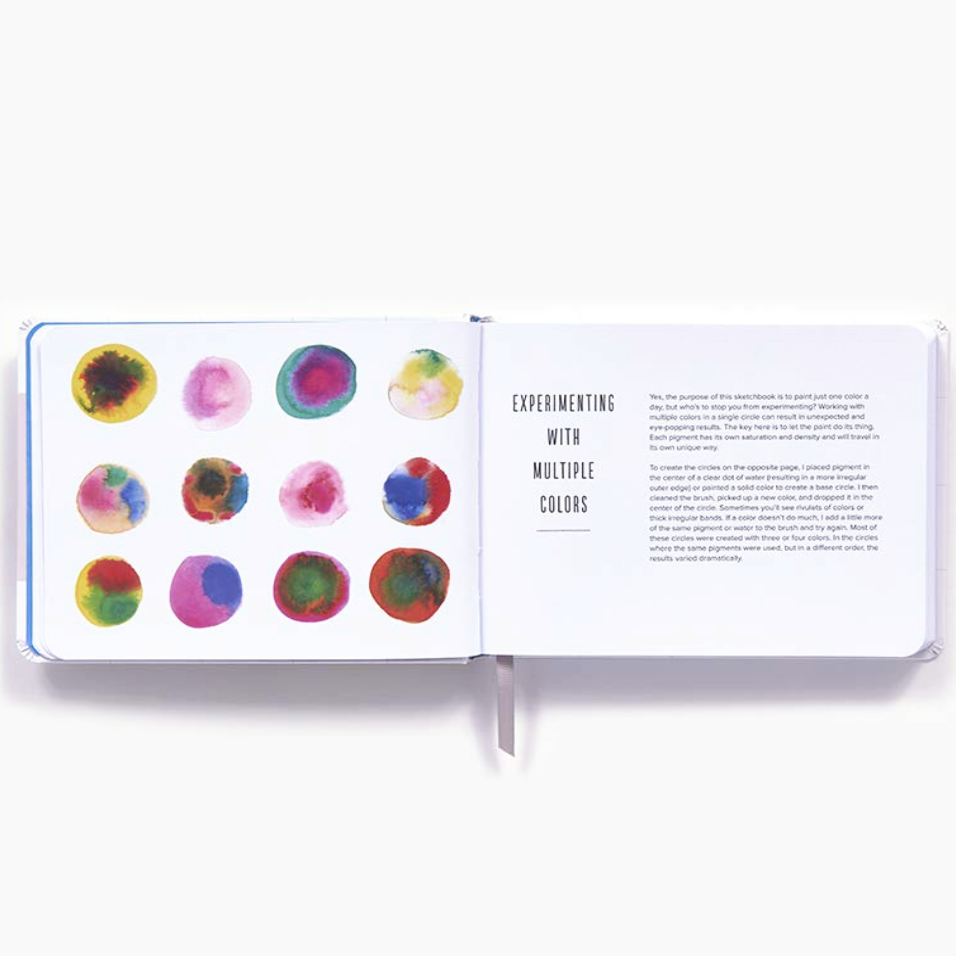 An open Color a Day book page on a white background, showing a left page with nine colorful watercolor circles and a right page with black text reading 'EXPERIMENTING WITH MULTIPLE COLORS'.