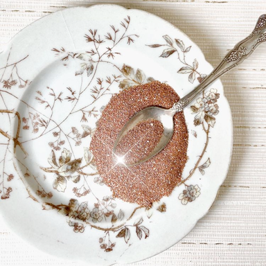 Authentic German Glass Glitter- Copper on a plate with spoon