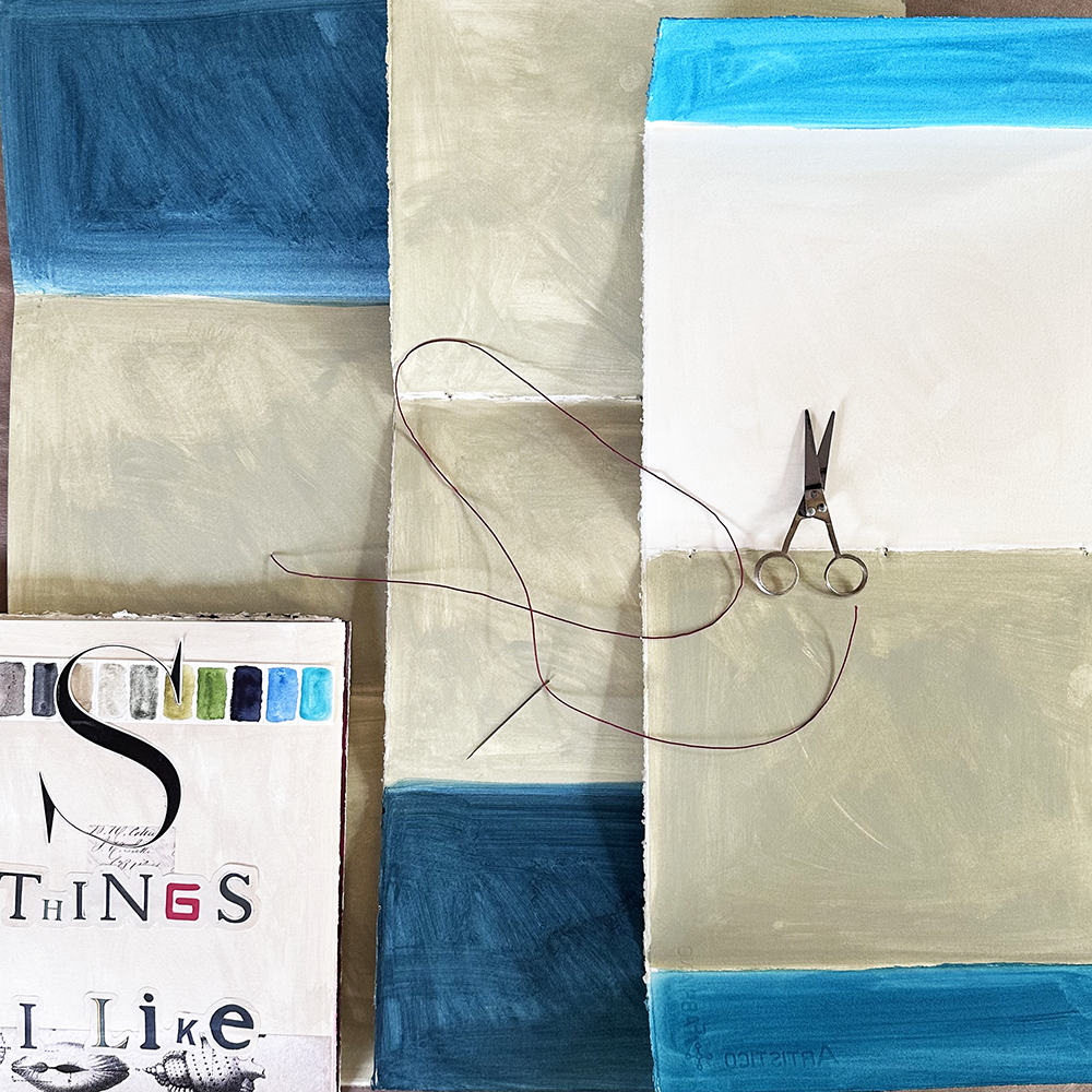 Visual Journaling - Return to the Analog World- painted pages before bound with string- work in progress shown with scissors