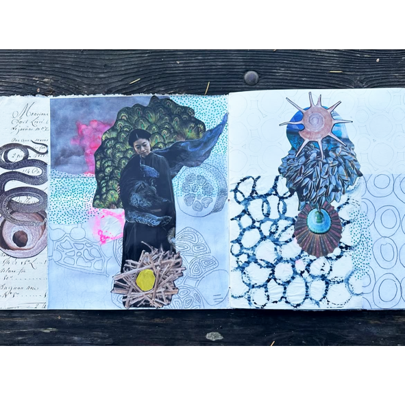 An open handmade art journal spread on a dark wooden surface, featuring three distinct illustrated and mixed-media columns with abstract figures, snakes, geometric patterns, and natural elements.