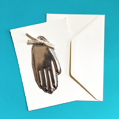 class samples of metal embossed hand ornament mounted onto a card with ribbon and an envelope