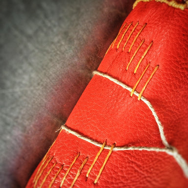 The Little Red Leather Journal Class sample Stitching on spine with orange thread and white string sewn underneath
