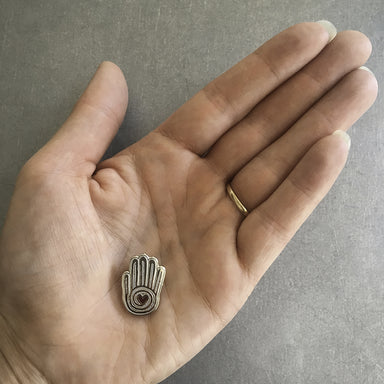 Mano Y corazon (hand and heart) pin  held in the palm of a hand