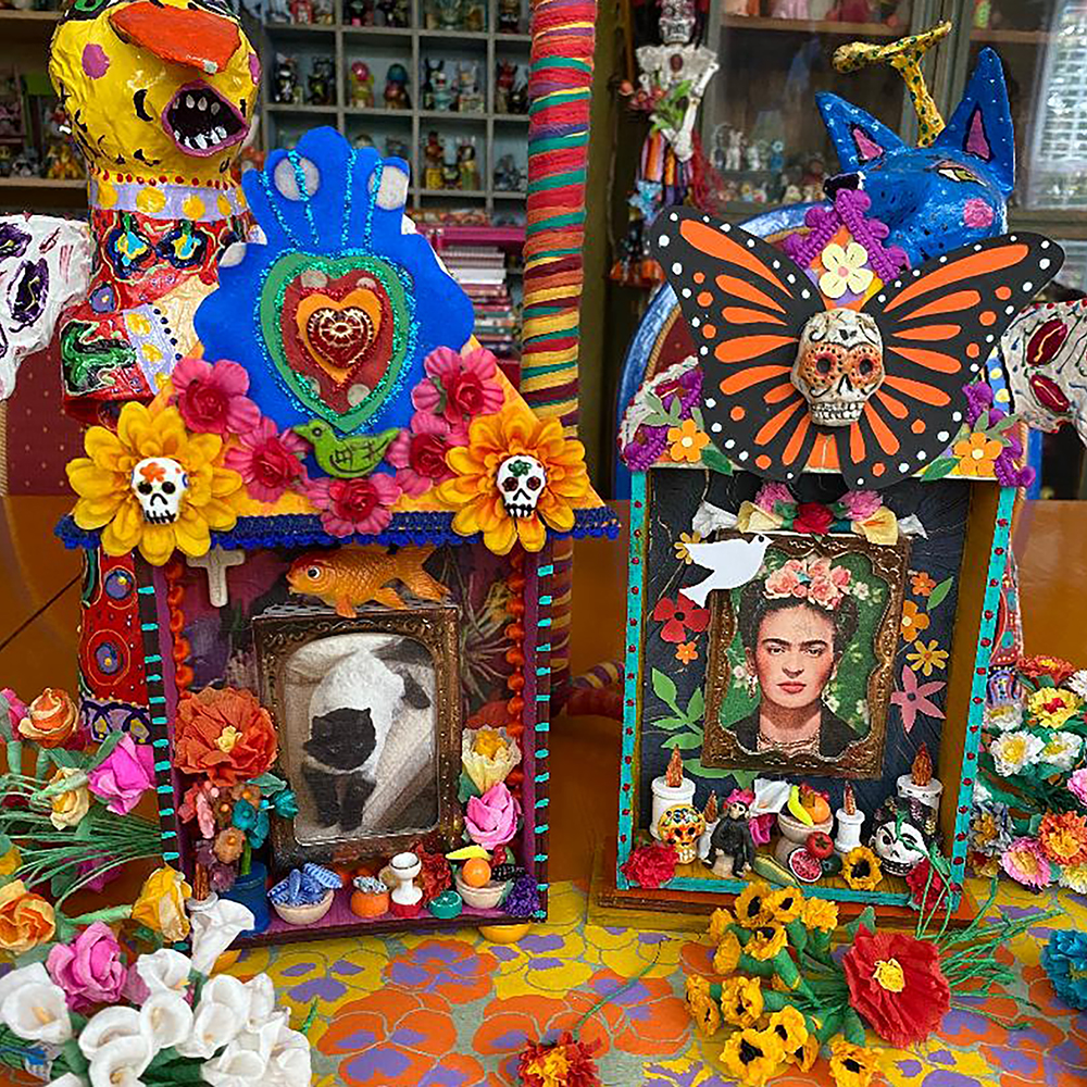 Ofrenda – Dia de Los Muertos class sample dedicated to a cat and Frida Kahlo on work bench with flowers