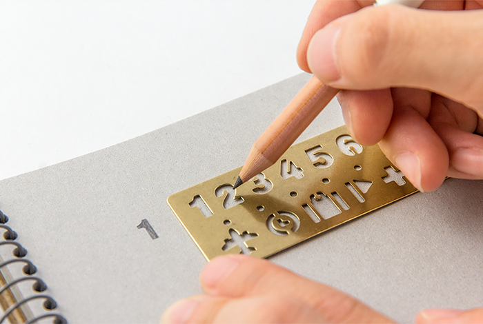 The Numbers Brass Bookmark allows you to mark the page of your favorite notebook and use the stencil to make clear labels and markers.