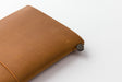 The Camel TRAVELER'S notebook Starter Kit features a metal closure to keep the elastic in place. 