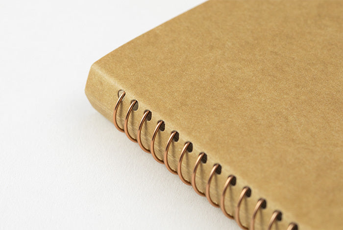 Midori spiral bound notebook has bronze colored coil. 