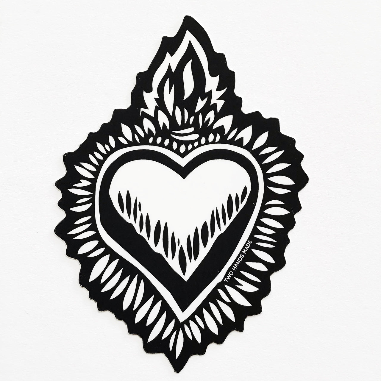 Two Hands Made Milagro Flaming Heart Vinyl Sticker- a heart to compliment any surface.