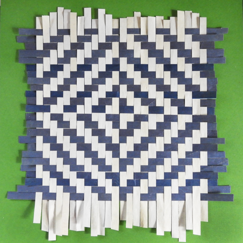 Paper Weaving sample using newsprint and blue paper on green background